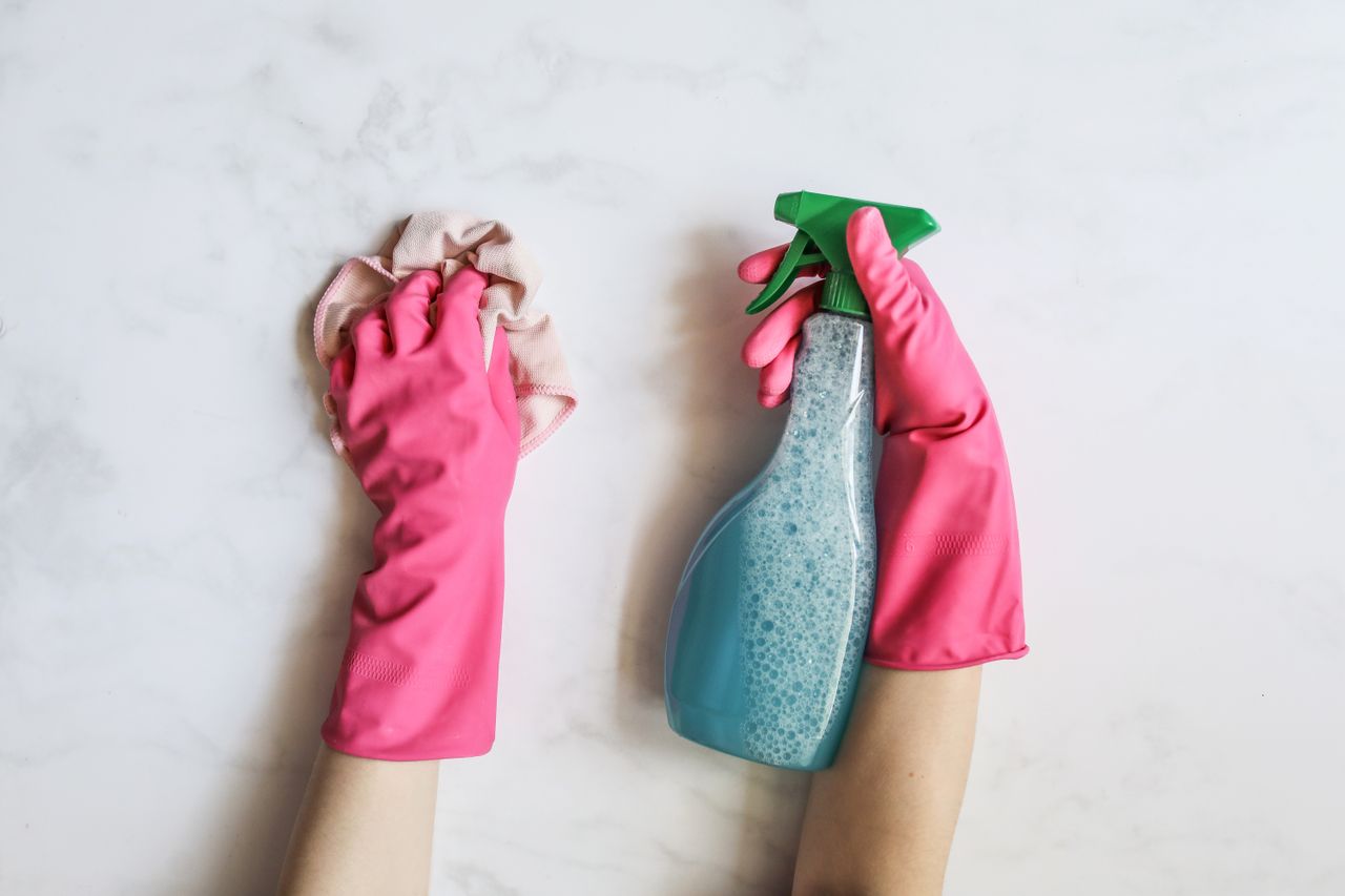 Schoonmaken met handschoenen en een sprayflacon voor klamvochtig werken