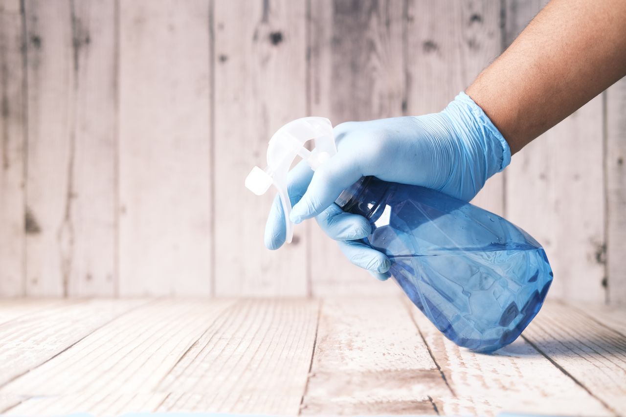 Schoonmaak met een sprayflacon en handschoenen